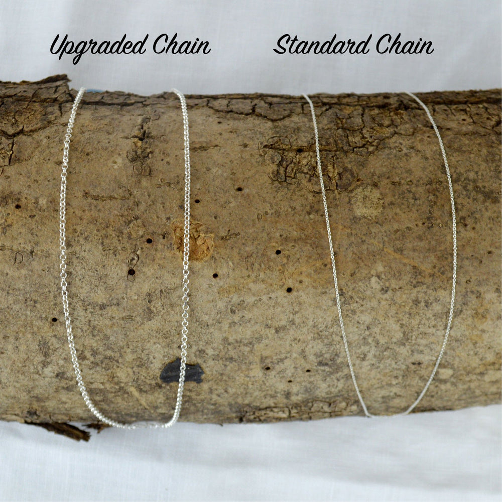 Two necklace chains on a log